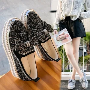 Vue détaillée de mocassins à plateforme noirs avec strass brillants et un nœud.