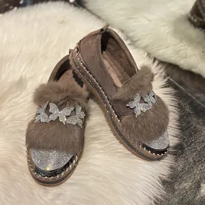 Detailed view of women's warm brown fur-lined loafers with sparkling butterfly rhinestones