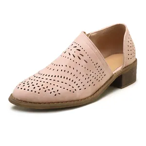 Detailed view of women's pink suede ankle boots with elegant laser-cut hollow patterns