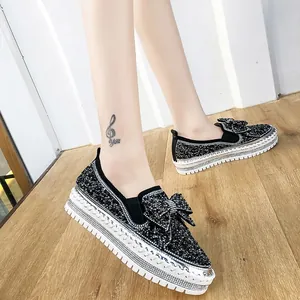 Gros plan de chaussures noires à strass avec nœud élégant et semelles compensées