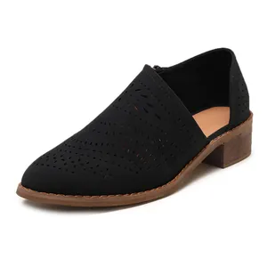 Close-up detail of black laser-cut chunky heel ankle bootie featuring a side cutout