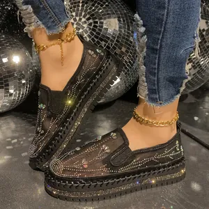 Close-up of black mesh loafers with butterfly rhinestone patterns and platform sole