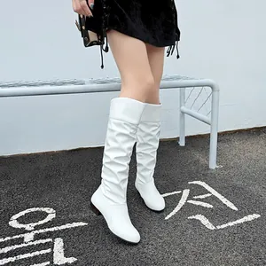 Close-up of white slouchy knee-high boots with round toe and flat heel design
