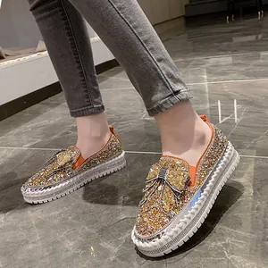 Vue détaillée de mocassins dorés à strass étincelants avec nœud et semelle plateforme épaisse