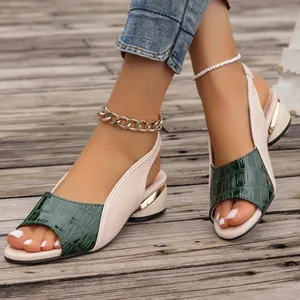 Close-up of green crocodile embossed peep-toe sandals with elegant gold heel detail.