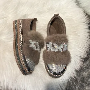 Close-up of warm winter loafers with butterfly rhinestone accents and faux fur trim