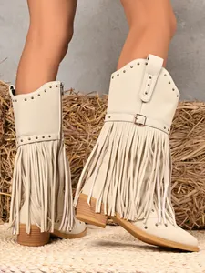 Detail of beige western cowboy boots featuring fringe, rivets, and a buckle strap