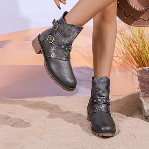 Vintage Western floral ankle boots with buckle detail on a sandy desert background.