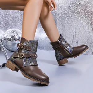 Close-up of brown western boots with floral print, double buckles and chunky heels