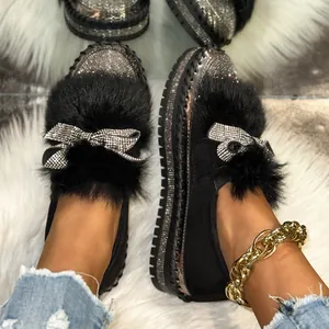 Detailansicht der schwarzen Loafer mit glitzernder Strass-Schleife und Kunstpelzbesatz