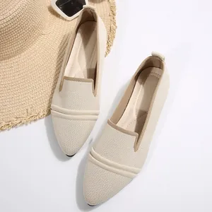 Close-up of beige pointed-toe knitted flat shoes with elegant textured woven surface