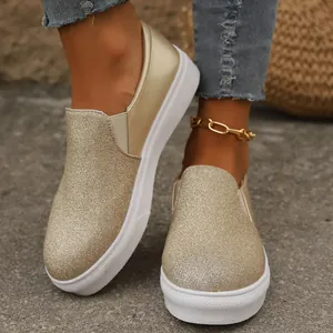 Nahaufnahme modischer goldener Glitzer-Slip-On-Loafer mit weißer Plateausohle für Damen