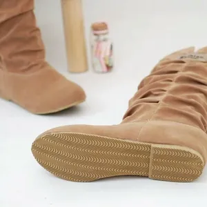 Detailed view of the non-slip rubber sole on women's camel suede mid-calf slouch boots