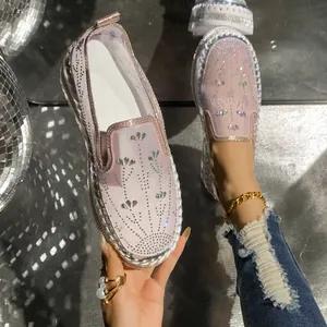 Close-up of pink loafers featuring heart rhinestone patterns and thick platform soles