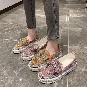 Gros plan sur des mocassins à nœud en strass avec semelles compensées roses et dorées