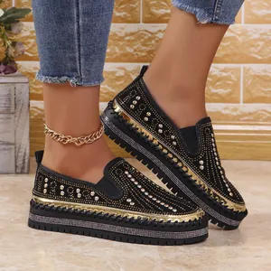 Dettaglio mocassini neri platform da donna con scintillanti decorazioni in strass dorati