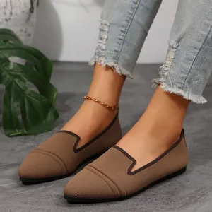 Close-up detail showing the breathable texture of pointed-toe knit flat shoes in brown.