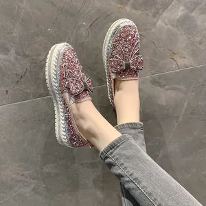 Gros plan de mocassins rose pailleté avec nœud en strass et épaisse semelle plateforme