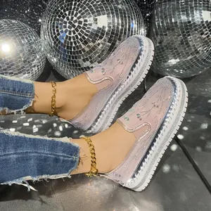 Detailed view of pink rhinestone platform loafers with sparkling disco ball background.