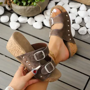 Détails de sandales compensées marron pour femme avec boucles et semelle liège.