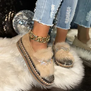 Detail view of plush fur loafers with sparkling butterfly rhinestone and thick sole
