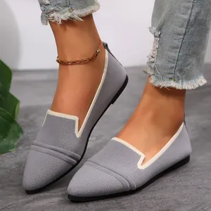 Close-up detail of grey pointed-toe fly-knit flats with contrasting white edge trim.