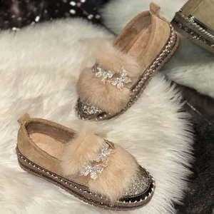 Detail view of women's loafers with fluffy fur and sparkling butterfly rhinestone ornaments.