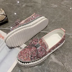 Détail de mocassins en strass roses avec un grand nœud et une semelle plateforme épaisse.