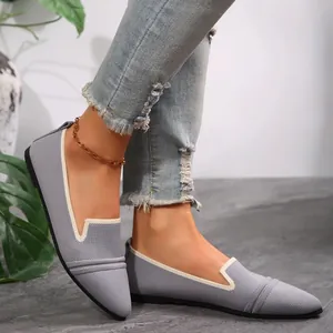 Close-up of grey pointed toe flyknit loafers with white trim and ribbed detail
