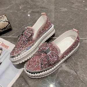 Gros plan sur des mocassins roses à strass avec nœud décoratif et semelle plateforme