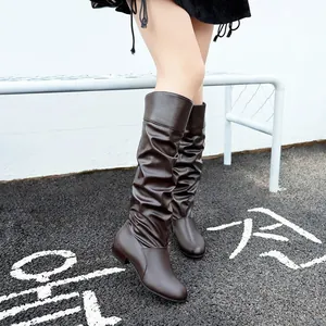 Detailed view of brown slouchy knee-high boots with round toe and flat sole