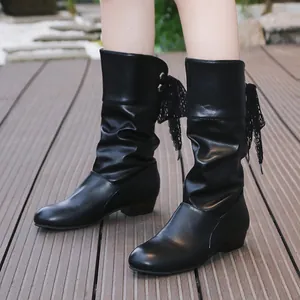 Detalle de botas negras fruncidas para mujer con un elegante lazo de encaje trasero.