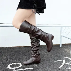 Stylish women's mid-calf slouched boots in brown with chunky heels and slip-on design.