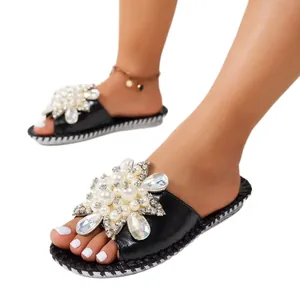 Elegant black flat slippers for women featuring exquisite pearl and crystal flower decor.