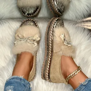 Detailansicht stilvoller beiger Pelz-Loafer mit Strassschleife und Bandverzierung.