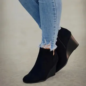 Modische schwarze Keilstiefeletten aus Wildleder für einen schicken Winter-Look.