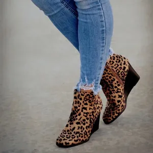 Elegante Damen Stiefeletten mit Keilabsatz und modischem Leopardenmuster auf Betonboden