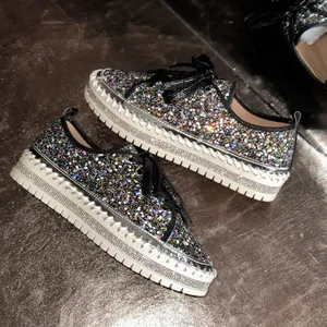 Detailansicht der glitzernden Plateau-Sneaker mit funkelnden Strasssteinen und Schnürung.