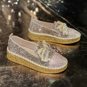 Close-up of sparkly rhinestone loafers with elegant bow detail and platform sole.