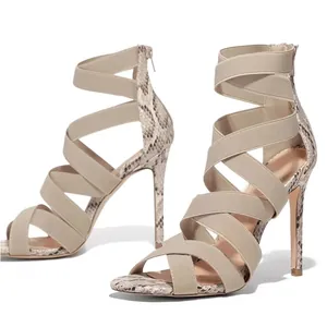 Detailed view of snake print stiletto sandals featuring beige elastic cross straps and zip.