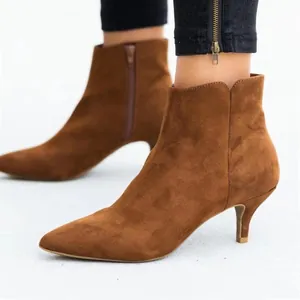 Bottines en daim marron à petits talons avec bout pointu et fermeture éclair.
