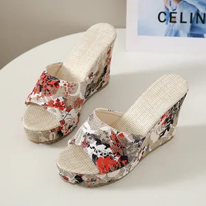 Side view of floral fabric wedge sandals with elegant peep-toe design on white table