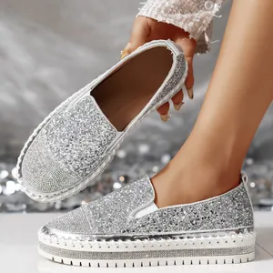 Dettaglio di mocassini argento glitterati con punta in strass e suola platform.