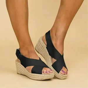 Close-up detail of stylish black cross-strap wedge sandals with jute rope espadrille sole.