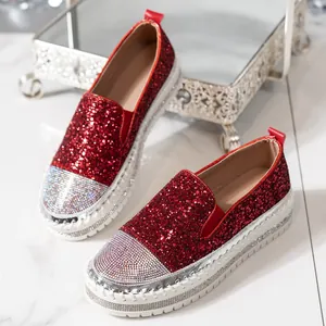 Mocassini rossi glitterati con punta di strass e suola platform bianca rinforzata.