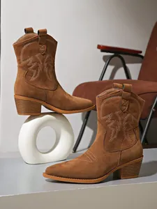 Macro view of vintage suede Western cowgirl boots featuring intricate embroidery details