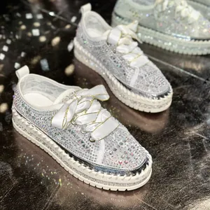 A detailed view of luxury white platform sneakers featuring colorful iridescent rhinestones