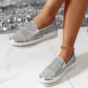 Dettaglio di mocassini argento glitterati da donna con punta decorata in strass lucidi