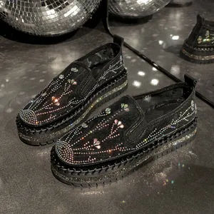 Close-up of stylish black loafers with sparkling rhinestones and thick platform soles