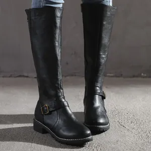 Women's black knee-high knight boots with buckle detail, flat leather style on model